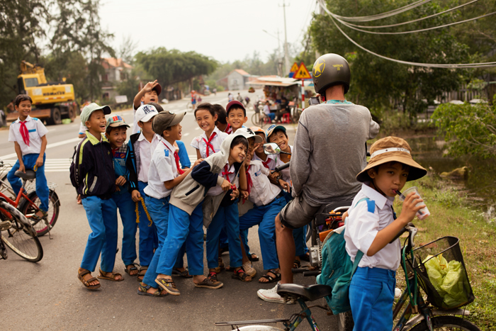 Množstvo deti vo Vietname na ceste s motorkárom.